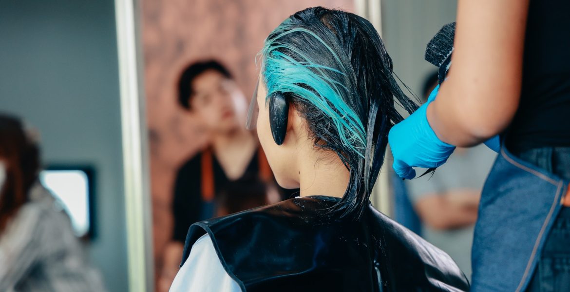 Hairdresser colouring hair of woman